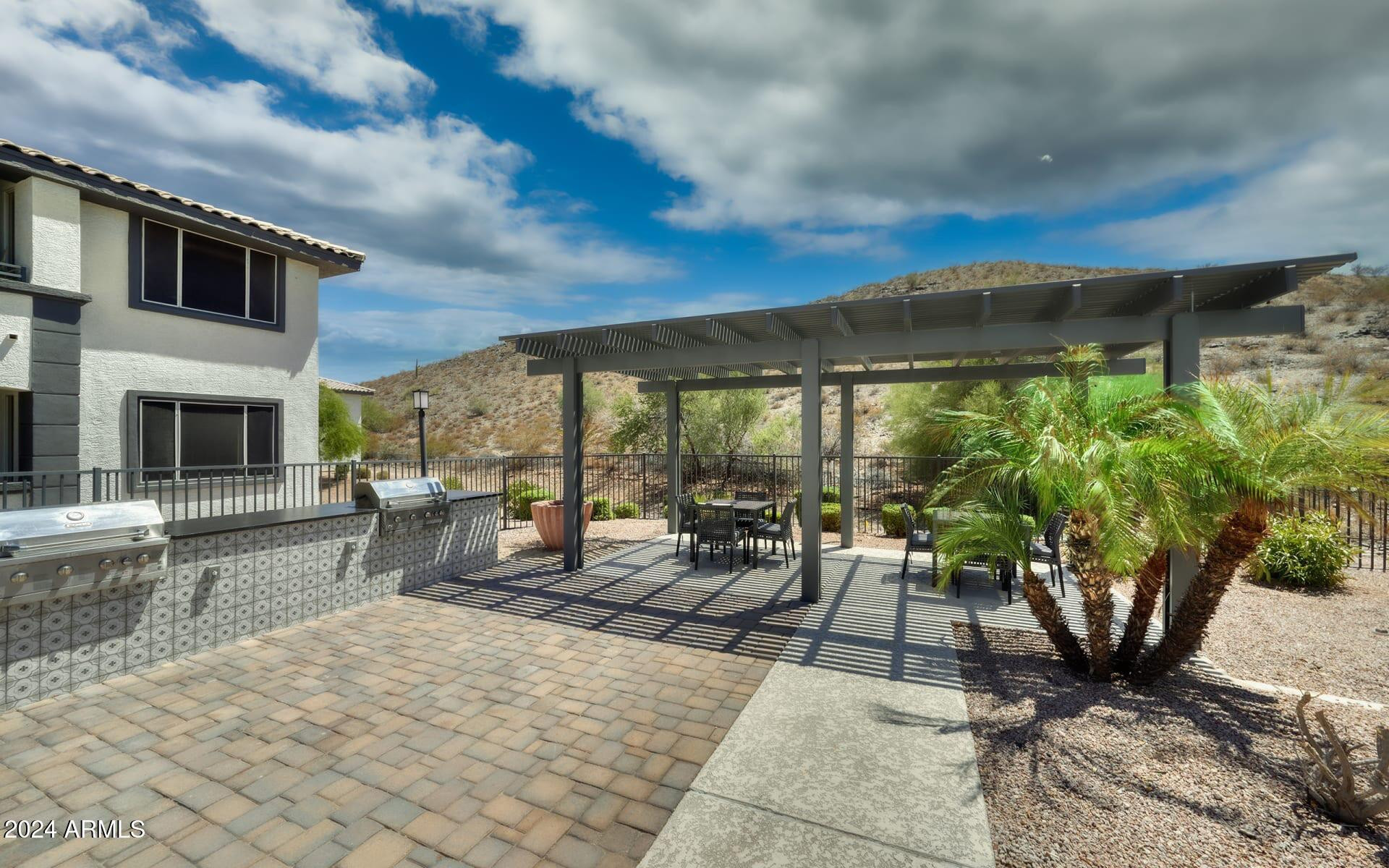 3625 East Ray Road, Unit 3 Phoenix, AZ 85044 - Photo 20 of 30 a view of a patio with table and chairs under an umbrella