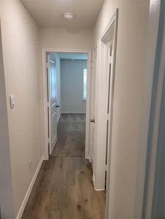 an empty room with wooden floor and mirror