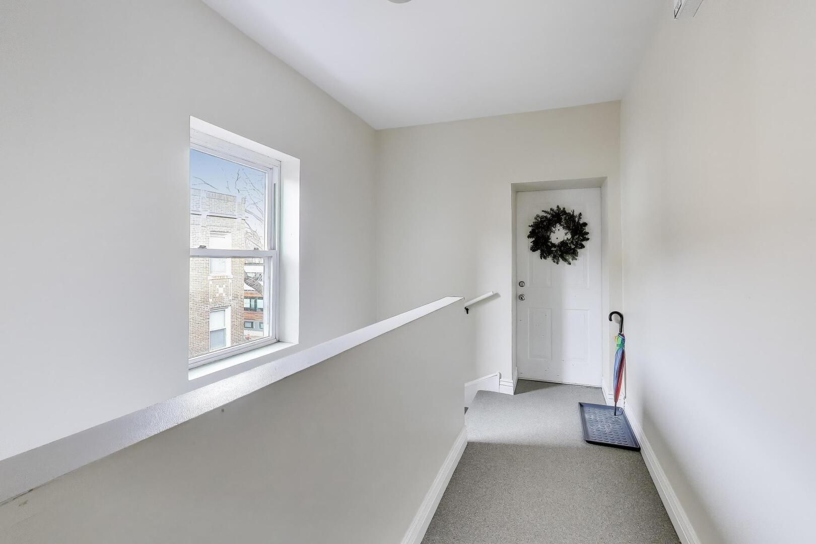1443 West Victoria Street, Unit 3E Chicago, IL 60660 - Photo 16 of 18 a view of hallway with window and stairs