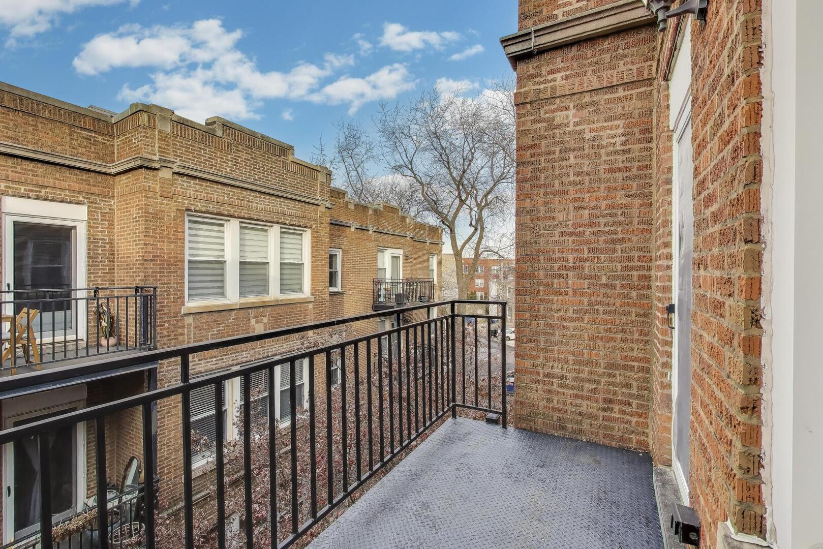 1443 West Victoria Street, Unit 3E Chicago, IL 60660 - Photo 5 of 18 a view of a brick house with a small yard