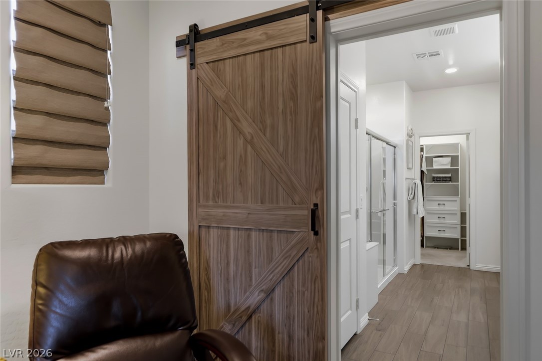 2922 Ventana Ridge Avenue Henderson, NV 89044 - Photo 26 of 57 The primary bedroom was upgraded with this attractive barn door for added privacy in the bathroom.