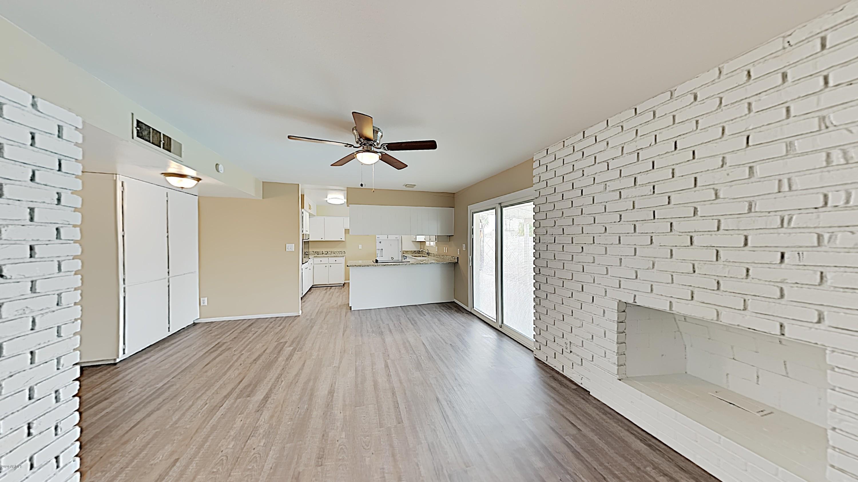 4110 West Hatcher Road Phoenix, AZ 85051 - Photo 3 of 19 a view of empty room with wooden floor and window