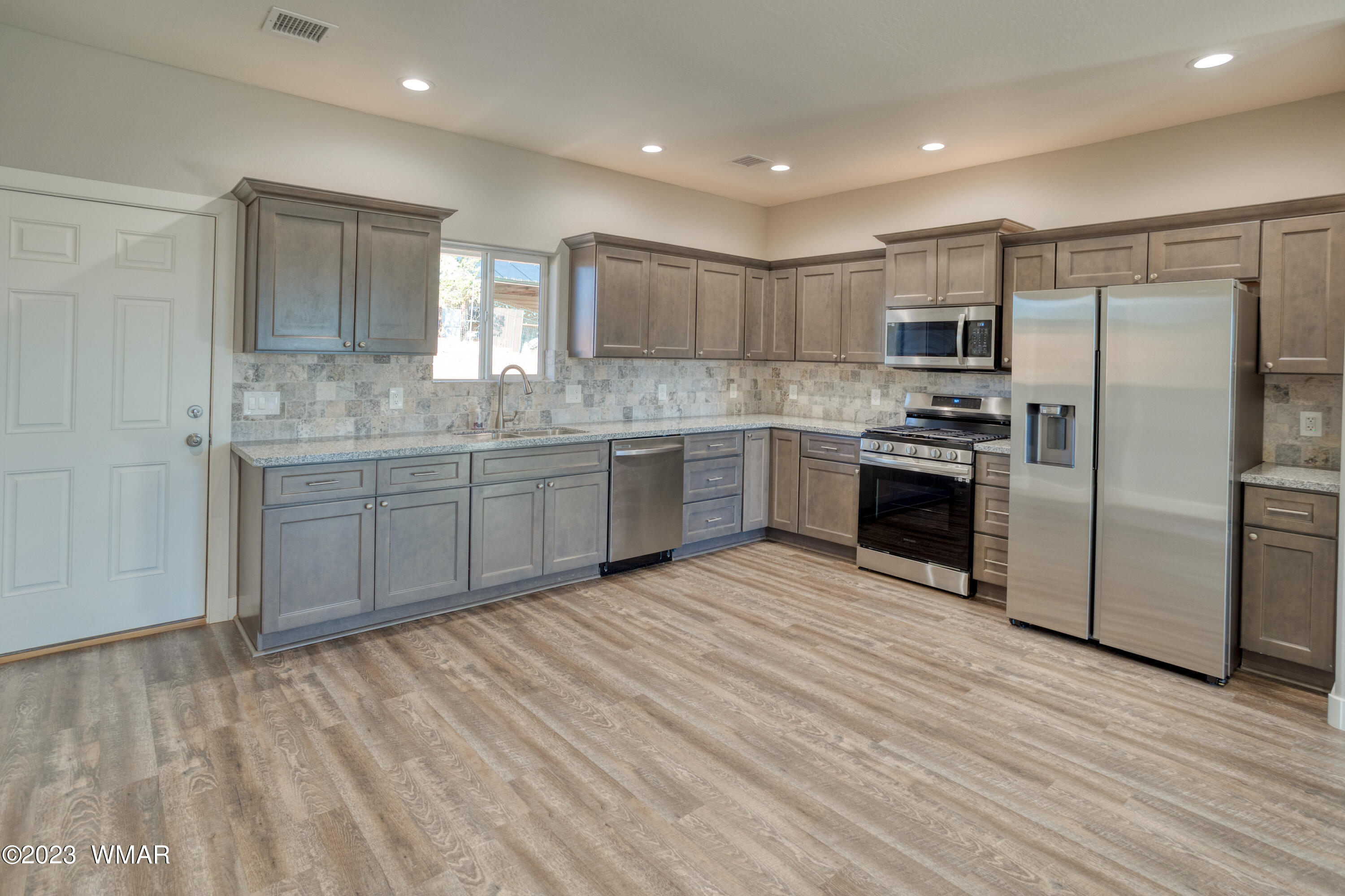 260 Granite Circle Taylor, AZ 85939 - Photo 2 of 11 a kitchen with stainless steel appliances granite countertop a stove a sink dishwasher a refrigerator and a oven with wooden floor
