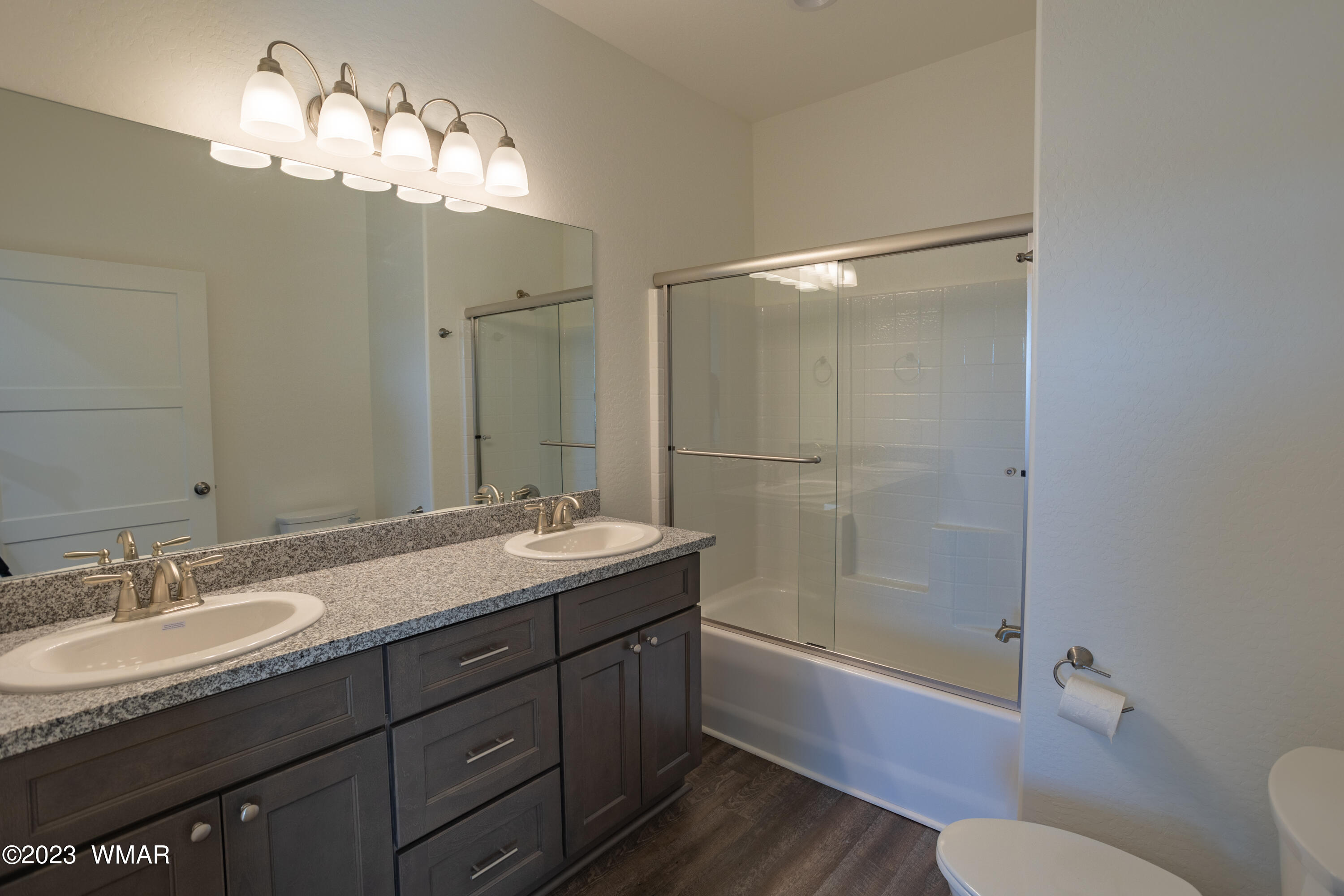 260 Granite Circle Taylor, AZ 85939 - Photo 10 of 11 a bathroom with a granite countertop sink toilet a mirror a bathtub and shower