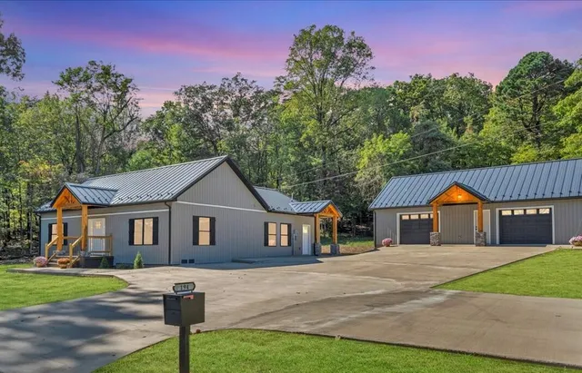 a front view of a house with a yard and trees