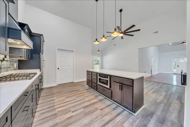 a kitchen with kitchen island a stove a sink and a refrigerator