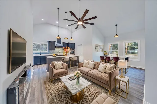 a living room with furniture a ceiling fan and a flat screen tv