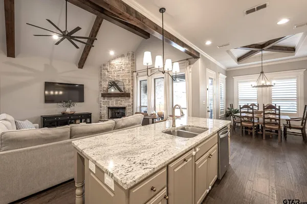a large living room with granite countertop kitchen island furniture and a chandelier