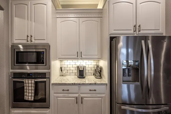 a kitchen with granite countertop stainless steel appliances and a refrigerator