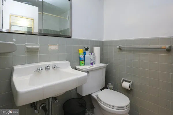 a bathroom with a sink a toilet and a mirror