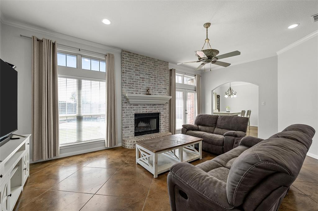 3696 Old Lorena Road Lorena, TX 76655 - Photo 4 of 27 Living area featuring acid-stained concrete flooring, a white-washed brick fireplace with a mantle, and large windows with transom accents
