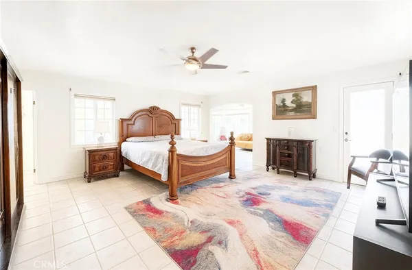 a spacious bedroom with a bed a fireplace and a chandelier
