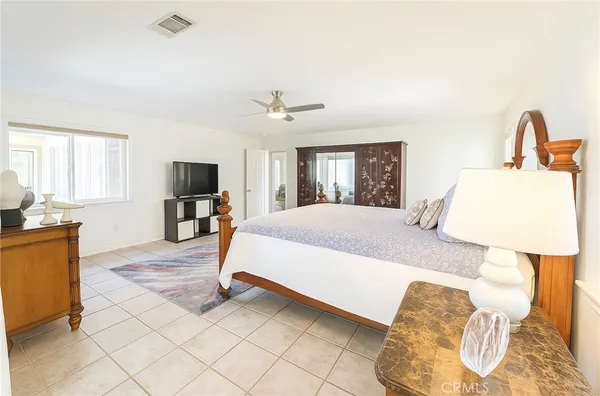 a bedroom with a bed flat screen tv and window