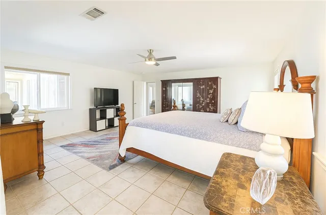 a bedroom with a bed flat screen tv and window