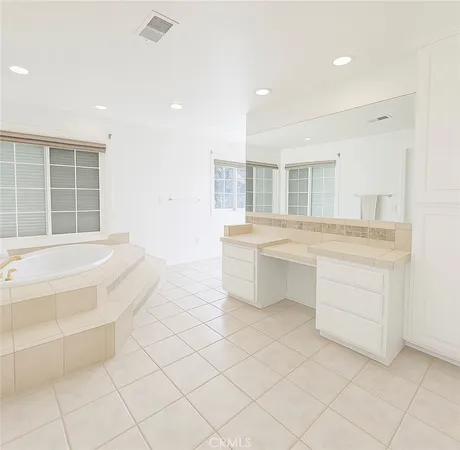 a spacious bathroom with a granite countertop sink mirror and bathtub