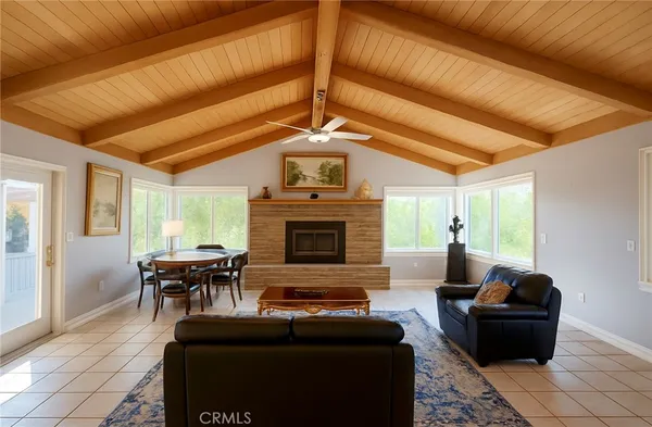 a living room with furniture a fireplace and large windows