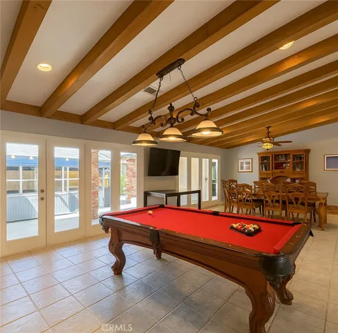 a bedroom with a bed a flat screen tv and balcony view