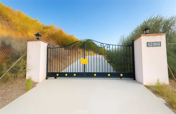 a view of a street with a small yard and a wooden fence