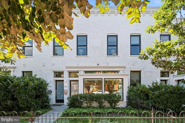 a front view of a house with plants