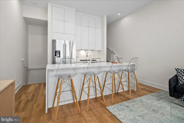 a kitchen with a table chairs in it and wooden floor