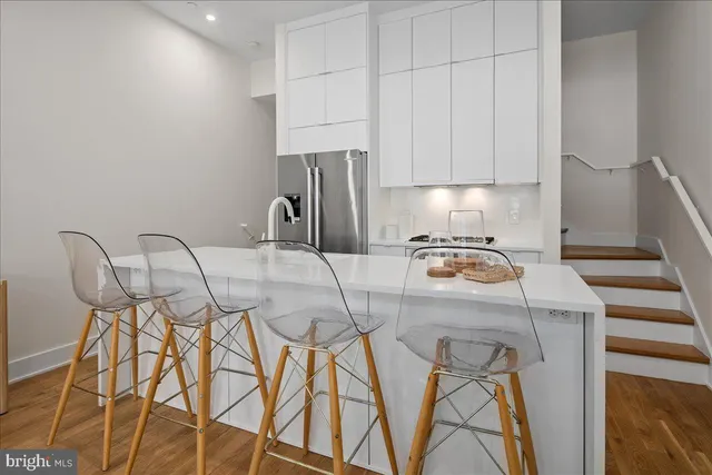 a kitchen with a table chairs and white cabinets