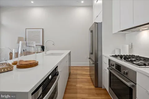 a kitchen with stainless steel appliances granite countertop a sink stove and refrigerator