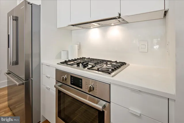 a stove top oven sitting inside of a kitchen