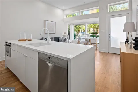 a view of a kitchen with a sink wooden cabinets and a window