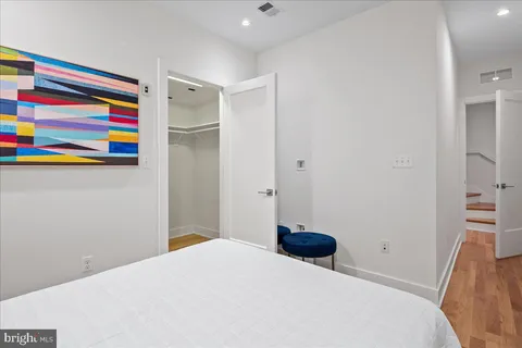 a bedroom with a bed and a painting on the wall