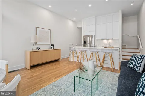 a living room with furniture a flat screen tv and kitchen view