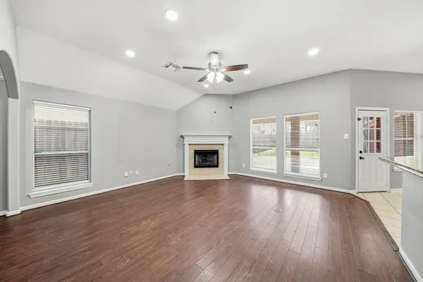 a view of empty room with wooden floor