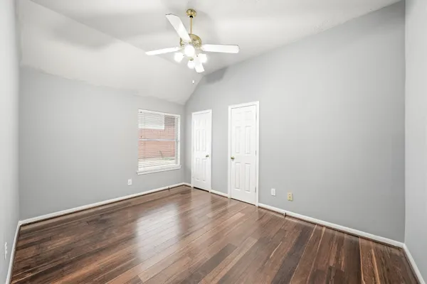 an empty room with a window and a ceiling fan