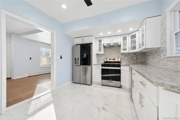 a kitchen with granite countertop a refrigerator and a sink