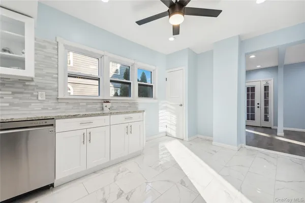 a spacious bathroom with a granite countertop sink a mirror and a bathtub