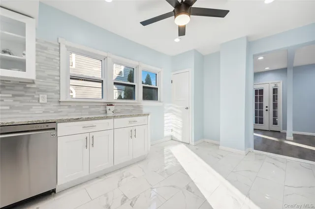 a spacious bathroom with a granite countertop sink a mirror and a bathtub