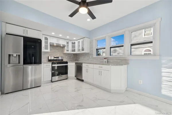 a kitchen with a white cabinets and window