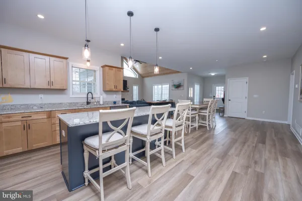 a dining area with a table chairs and a kitchen view