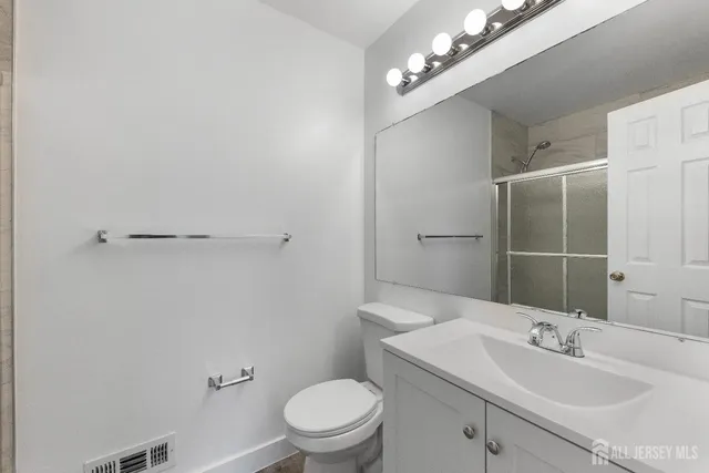 a bathroom with a sink a toilet and shower