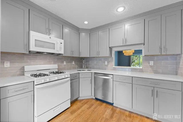 a kitchen with white cabinets stainless steel appliances and sink