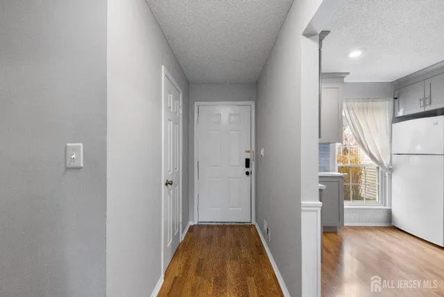 a view of hallway with stairs and wooden floor