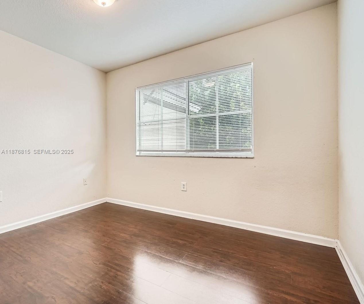 13945 Southwest 279th Lane, Unit 13945 Homestead, FL 33032 - Photo 11 of 14 an empty room with wooden floor and windows