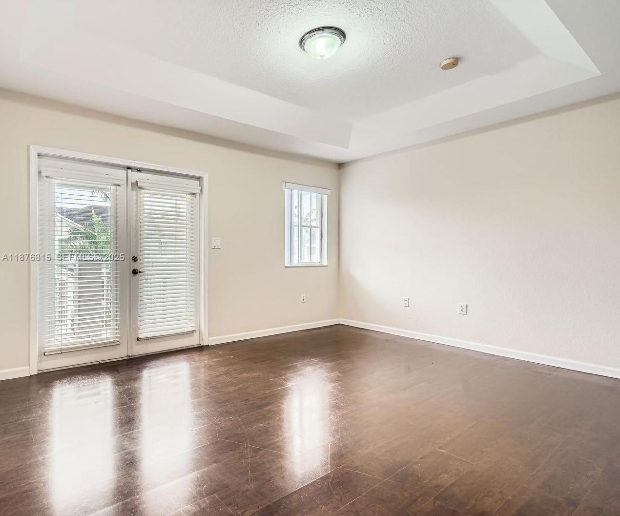 13945 Southwest 279th Lane, Unit 13945 Homestead, FL 33032 - Photo 12 of 14 an empty room with wooden floor and windows