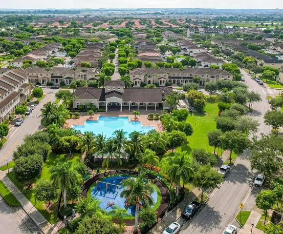 an aerial view of residential houses with outdoor space and swimming pool