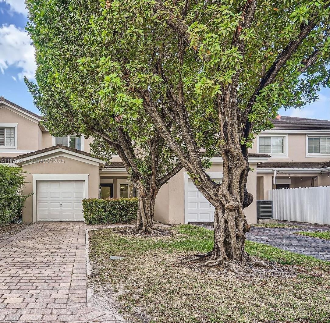 13945 Southwest 279th Lane, Unit 13945 Homestead, FL 33032 - Photo 2 of 14 a tree in front of a white house