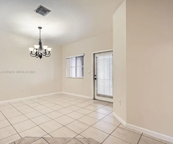 a view of an empty room with chandelier