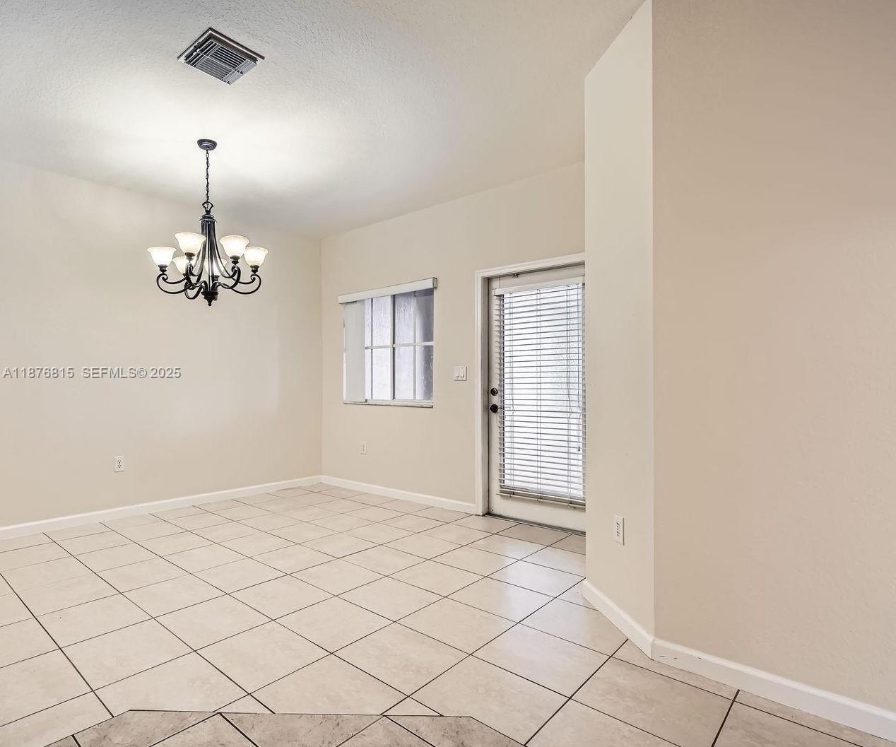 13945 Southwest 279th Lane, Unit 13945 Homestead, FL 33032 - Photo 6 of 14 a view of an empty room with chandelier