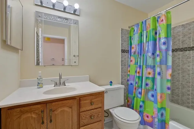 a bathroom with a sink toilet vanity and shower