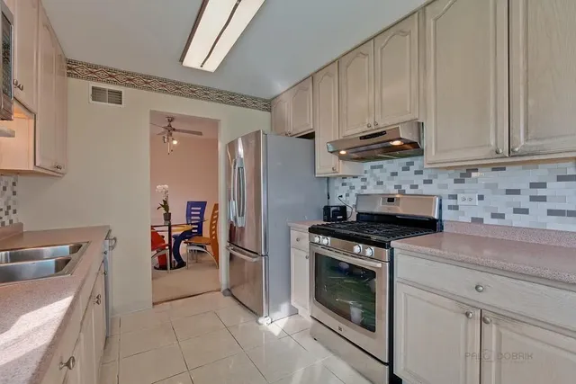 a kitchen with stainless steel appliances granite countertop a stove a refrigerator and a sink