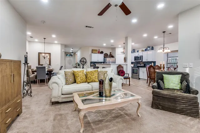 a living room with furniture kitchen view and a large window
