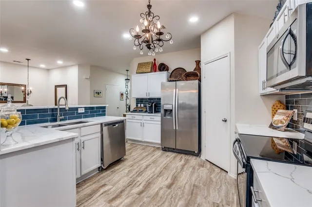 a kitchen with stainless steel appliances granite countertop a sink refrigerator and cabinets